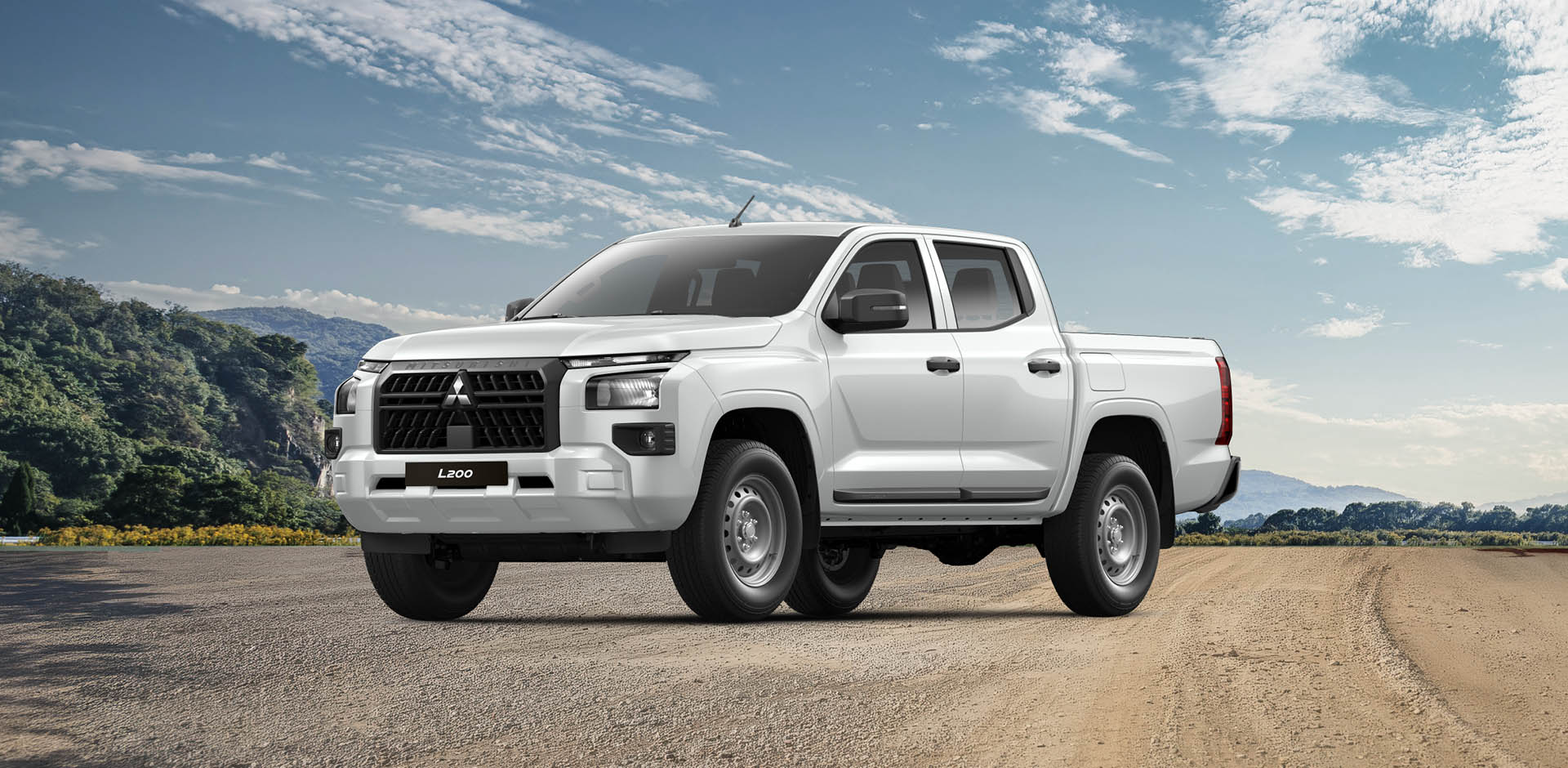 Front- und Seitenansicht eines weißen Mitsubishi L200 Pickups, geparkt auf einer Landstraße vor bewaldeten Hügeln und blauem Himmel.