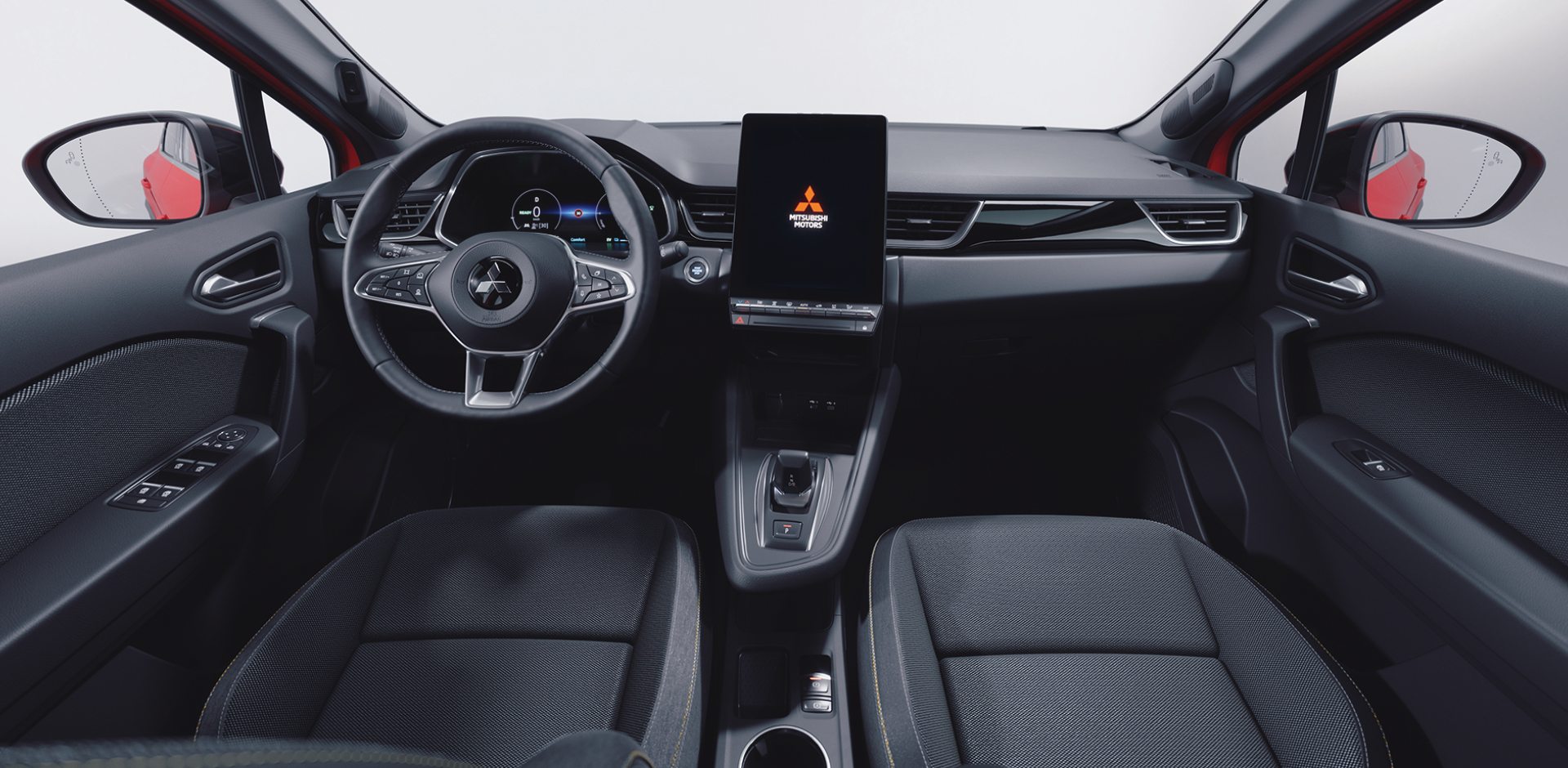 Innenansicht des Mitsubishi ASX Select: Blick von hinten auf Cockpit mit Multifunktionslenkrad, großem zentralen Touchscreen mit Mitsubishi Motors Logo, Mittelkonsole und zwei Vordersitzen.