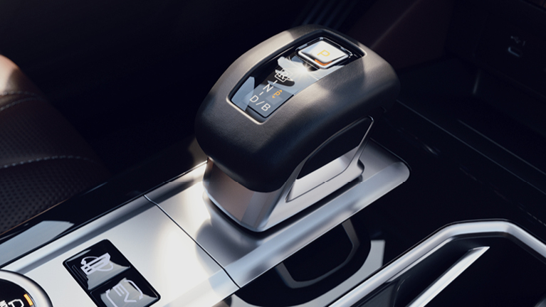Detailaufnahme der Mittelkonsole eines Outlander Plug-in Hybrid Select mit modernem, elektronischem Gangwahlhebel in Parkstellung und hochwertigen Oberflächen in Schwarz und Silber.