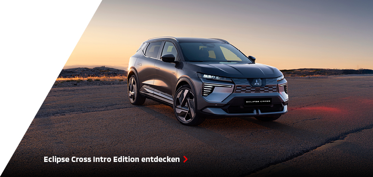 Graue Mitsubishi Eclipse Cross Intro Edition steht schräg von vorn auf einer Straße in offener Landschaft bei Sonnenuntergang, betont als dynamischer Crossover-SUV für stilvolles Fahren.